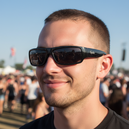 Close up portrait of guy with buzz cut and black wraparound sunglasses at festival